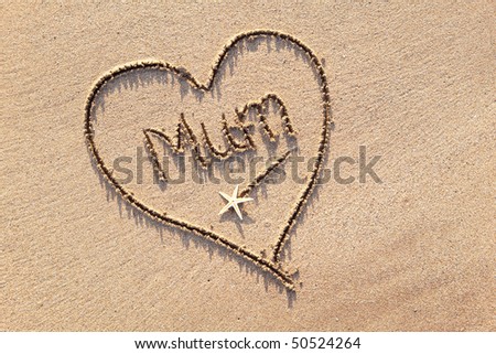 close up of word \'mum\' drawn in heart in sand