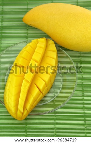 Ripe mango on the plate glass.