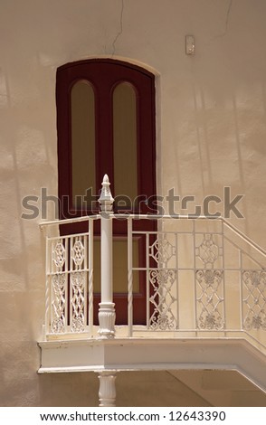 The side door, classic old turn of the century door and wrought iron staircase