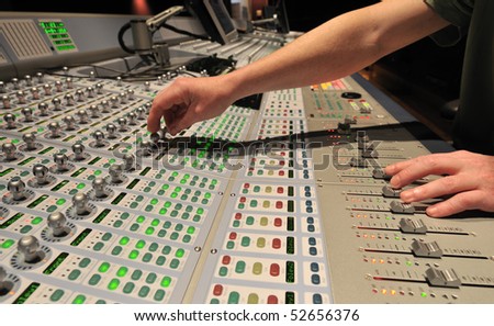 Audio engineer operating mixing console with hands