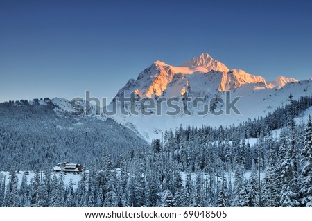 Mount Shuksan winter sunset with ski lodge at the foot of the mountain
