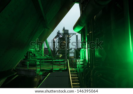 night view of a historical steel factory in duisburg, germany, with a green lamp, shining from the side, in the foreground