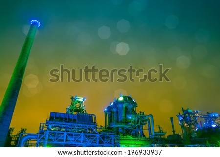 historic, old steel factory at night with illuminated color lighting, from green to blue, and real bokeh shapes