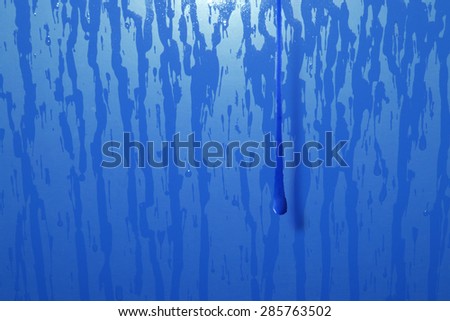 flowing paint drop, hovering on a blue ground with water trails