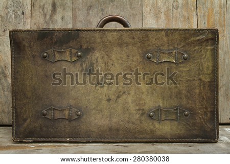 Travel concept on wood background with antique leather luggage