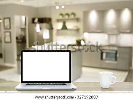 Laptop white screen and coffee cup on marble table with kitchen background.