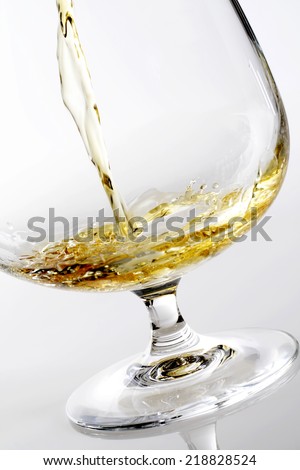 pouring brandy isolated on white