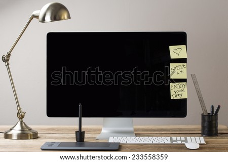 image of a computer screen with a lamp and drawing tablet, with sticky notes