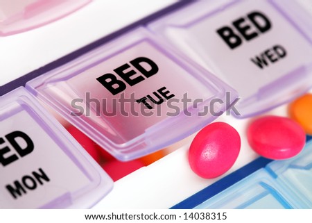 orange tablets on top of medicine distributor