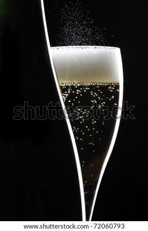 champagne glass and bottle on black background