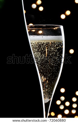 champagne glass and bottle on black background