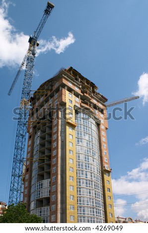 building under construction and hoisting crane