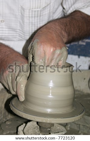 potter making vase from clay on the wheel