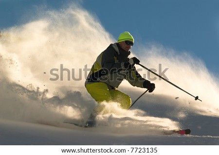 man on ski tear at full speed in clouds of snow powder