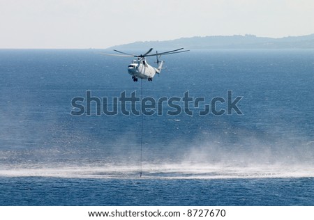 fire fighting helicopter pick up water from sea