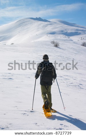 backpacker in snow shoes going to snow mountain