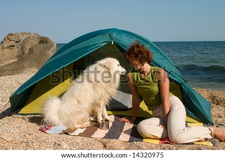 hiker girl and samoyed dog near of tent