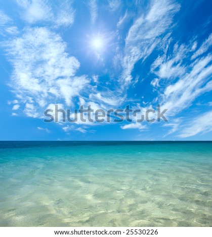 Blue sea and sun in the sky with clouds