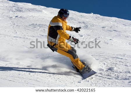 snowboarder in yellow suite on the snow slope