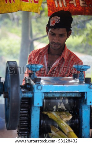 GOA, INDIA - DECEMBER 16: Man making a fresh cane juice on a country road on December 13, 2009 in Goa, India. Sweet cane juice is a main refreshment in Indian countryside.
