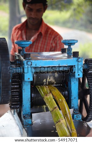GOA, INDIA - DECEMBER 16: Man making a fresh cane juice on a country road in Goa, India at 16 of December 2009. Sweet cane juice is a main refreshment in Indian countryside.