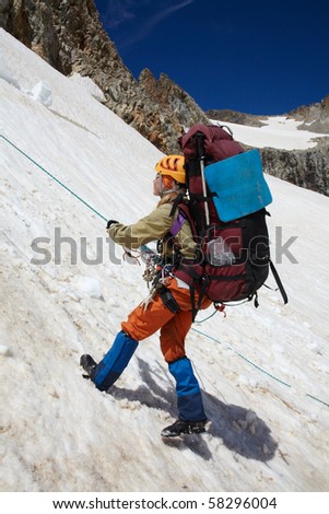 Girl moving down on snow with rope belay