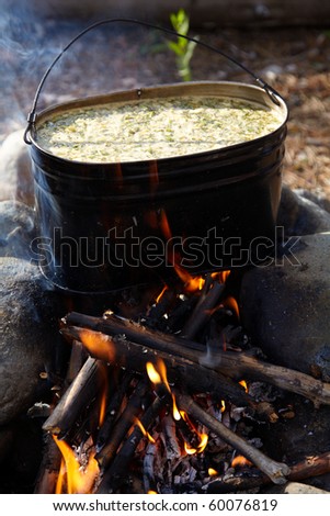 Making a food in a kettle on campfire