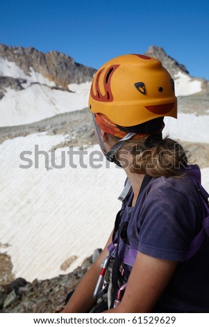 Hiker girl in orange helmet looking to far mountains