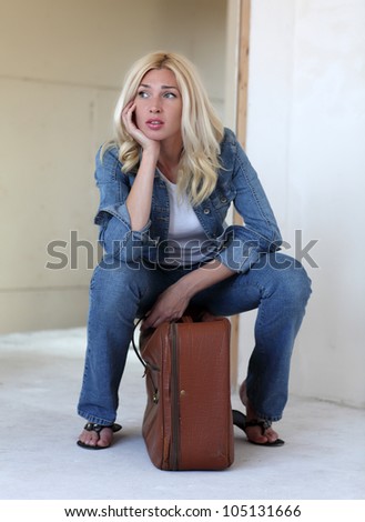 Homeless Woman. Young woman sitting on a suitcase