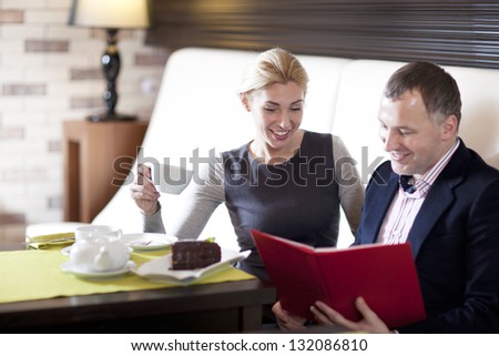 happy couple dining out in restaurant and reading menu