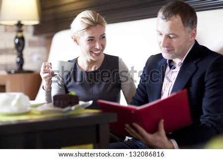 happy couple dining out in restaurant and reading menu