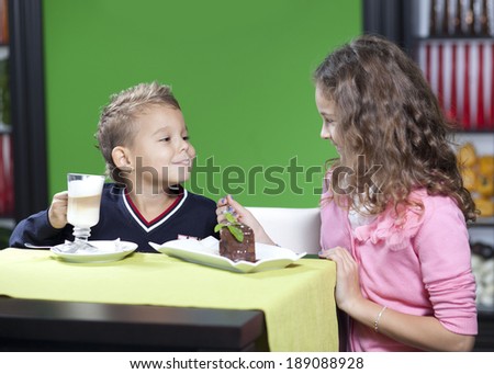 The little boy and his elder sister in cafe have fun