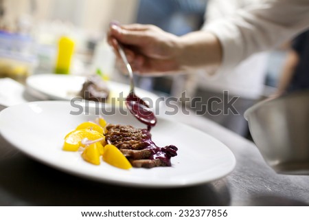 Chef is decorating delicious dish, motion blur on hands