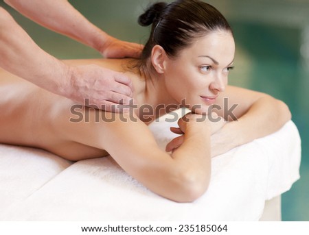 health, beauty, resort and relaxation concept - beautiful woman in spa salon getting massage