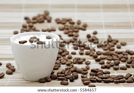cup of coffee with cream with coffee seeds