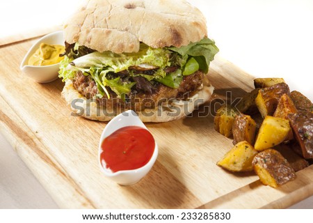 big hamburger with potatoes and ketchup