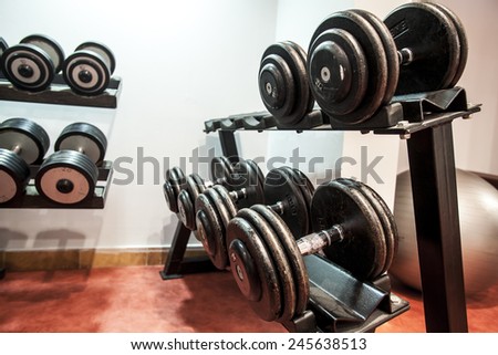 Rows of dumbbells in the gym trough an retro photo filter