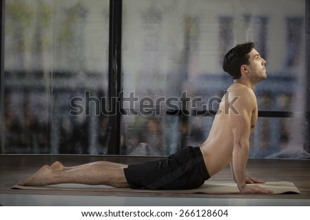 young man doing yoga in office