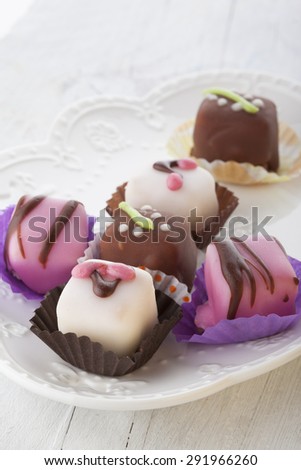 Mignon small sweet cakes on a wooden white board