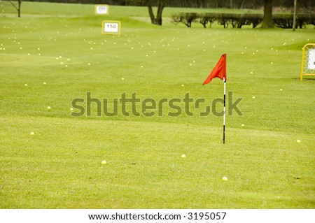A view of a driving range with flags fluttering in the wind