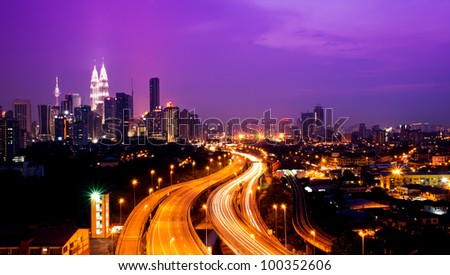 Kuala Lumpur twin towers with stunning light trail from the busy highway traffic.
