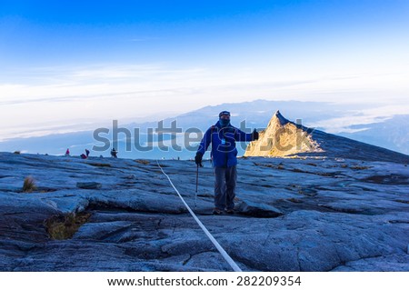 Hikers hiking Mount Kinabalu at early morning. Hiking in view of low light condition.