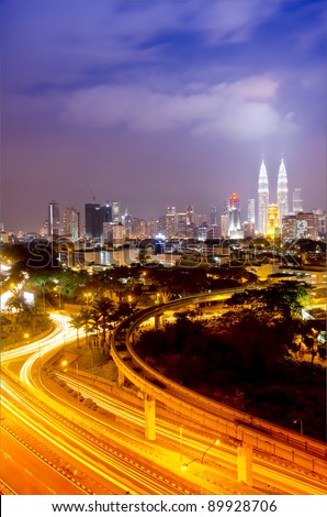 Scenery of Kuala Lumpur twin towers with stunning light trail from the busy highway traffic.