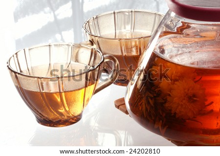 Hot flower tea in a transparent teapot.
