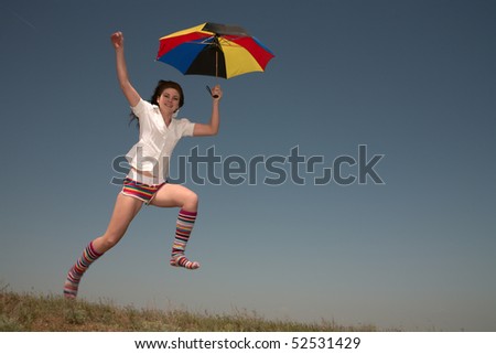 Girl with a color umbrella  jumps highly upwards.