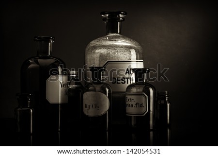 Arrangement of old pharmacy bottles, sepia toned