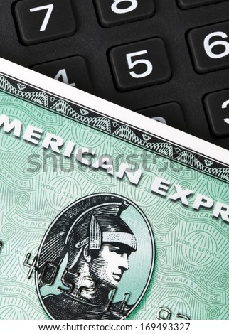 Ratingen, Germany - June 21, 2011: Closeup of green American Express credit card on a number pad. AMEX is one of the biggest credit card companies worldwide. Studio shot.