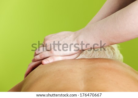 Hands of female massage therapist pressing a woman\'s shoulders