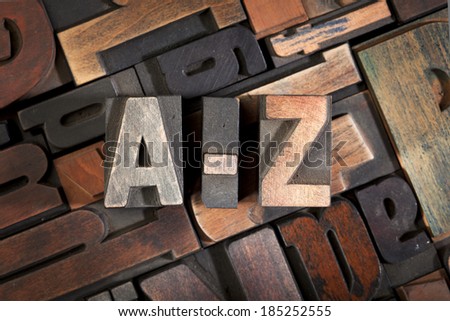 a-z written with vintage letterpress printing blocks on random letters background