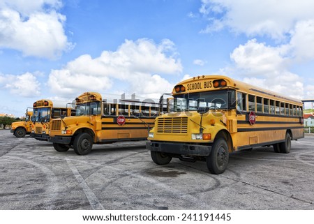 Four school buses waiting in parking lot
